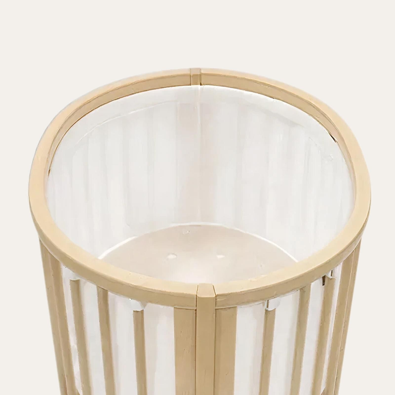 Un berceau rond en bois avec des barreaux verticaux transparents.