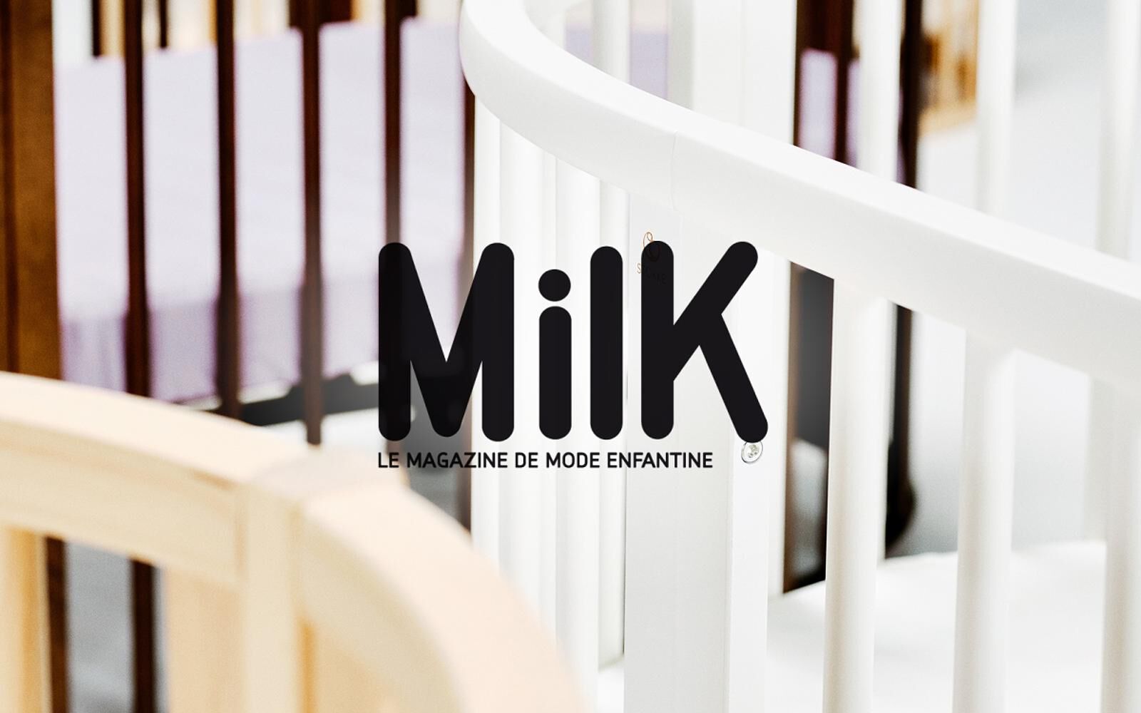 Logo du magazine 'MiLK' sur des parties floues du berceau Stokke Sleepi en bois blanc et naturel.