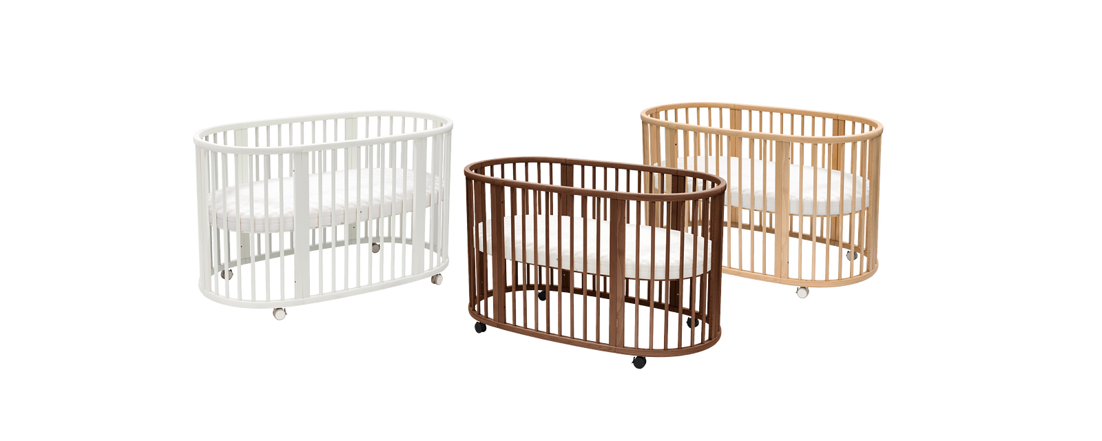 Three oval wooden baby cribs with slats in white, brown, and natural wood, on wheels.