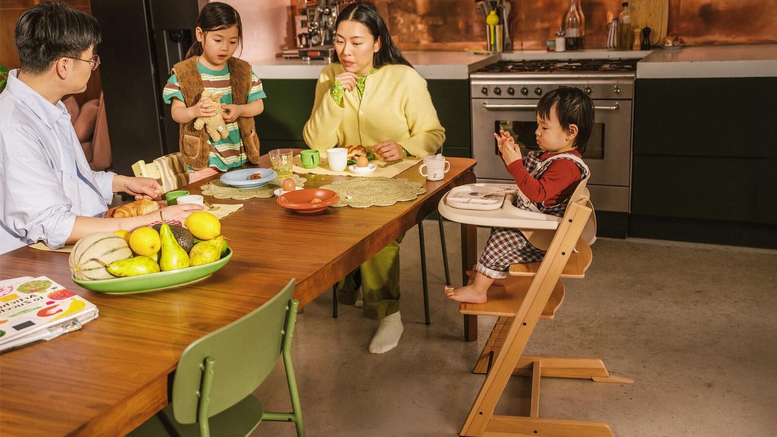 Familie beim Frühstück. Kleinkind sitzt in einem Tripp Trapp Hochstuhl mit Baby Set am Tisch.