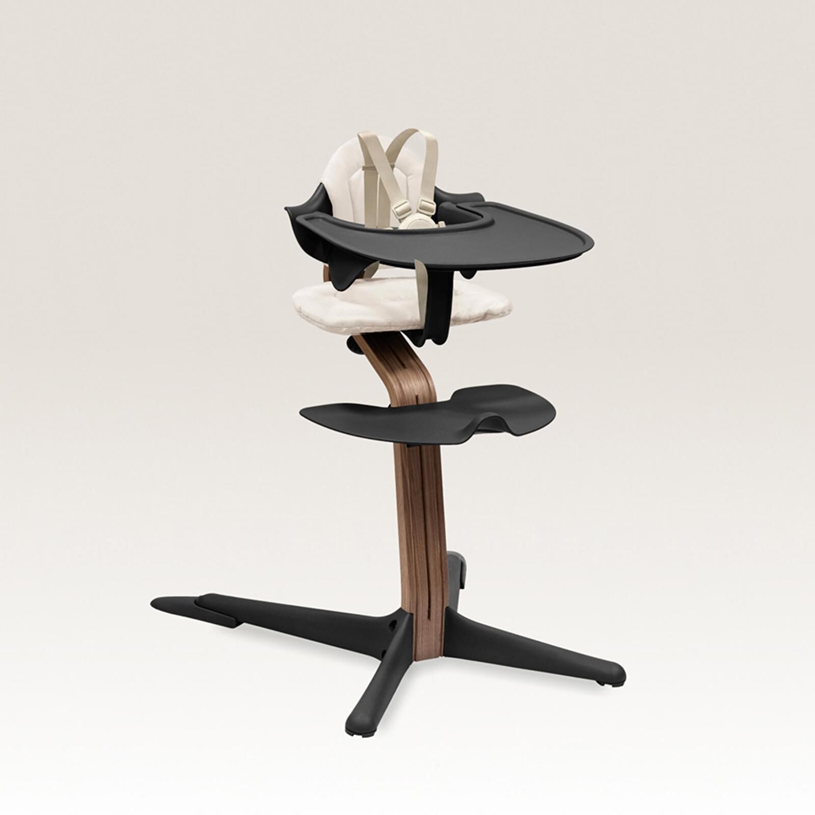 Un moderno seggiolone nero e in legno con un cuscino color crema e un'imbracatura.