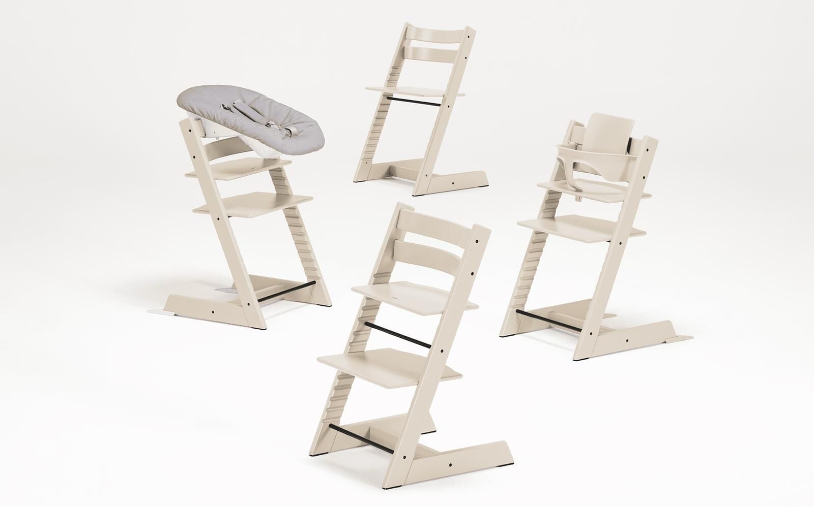 Vier Tripp Trapp stoelen: twee kinderstoelen (Newborn Set, Baby Set) en twee standaard stoelen.