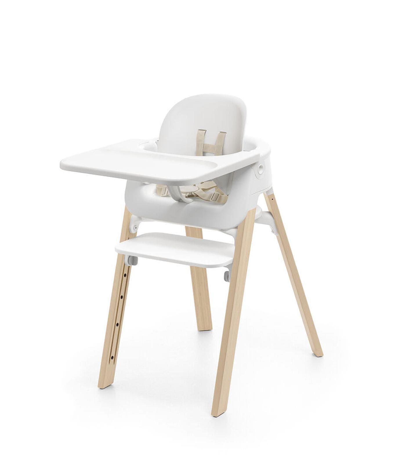 White baby high chair with wooden legs and a tray.