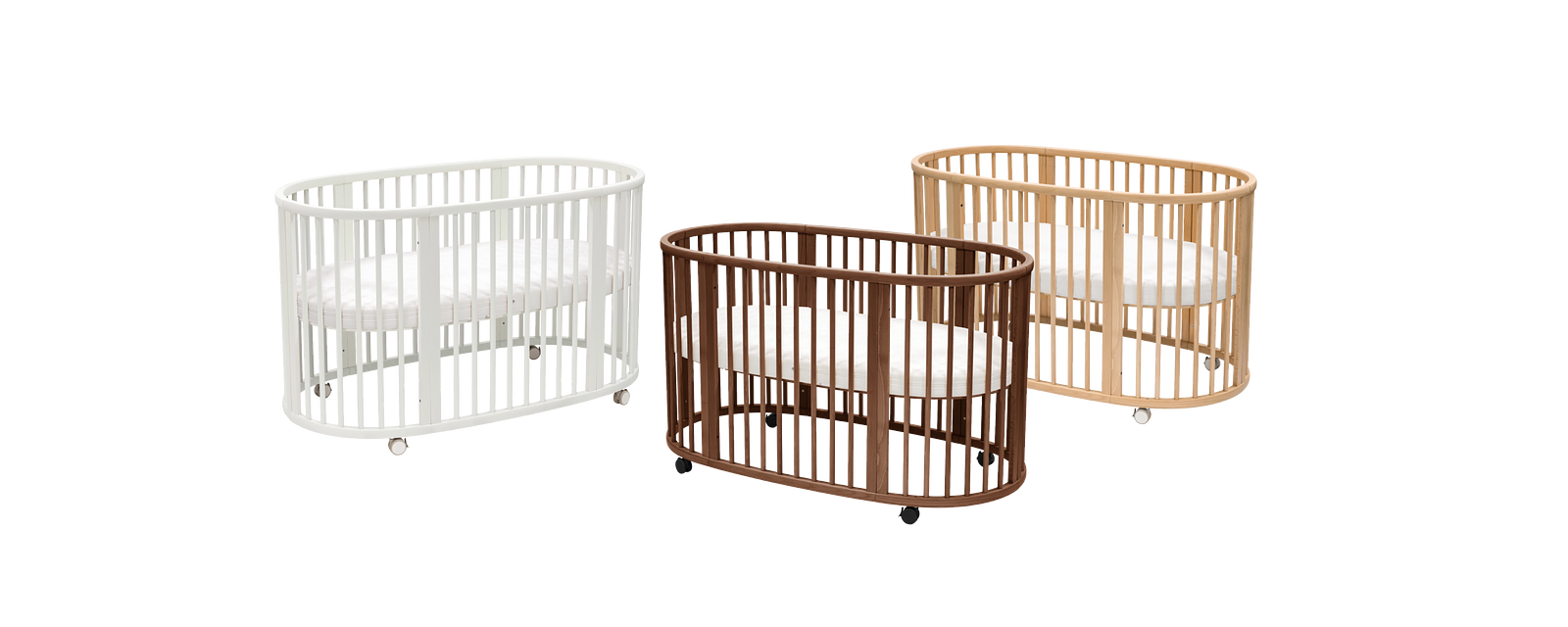 Three oval wooden baby cribs with slats in white, brown, and natural wood, on wheels.