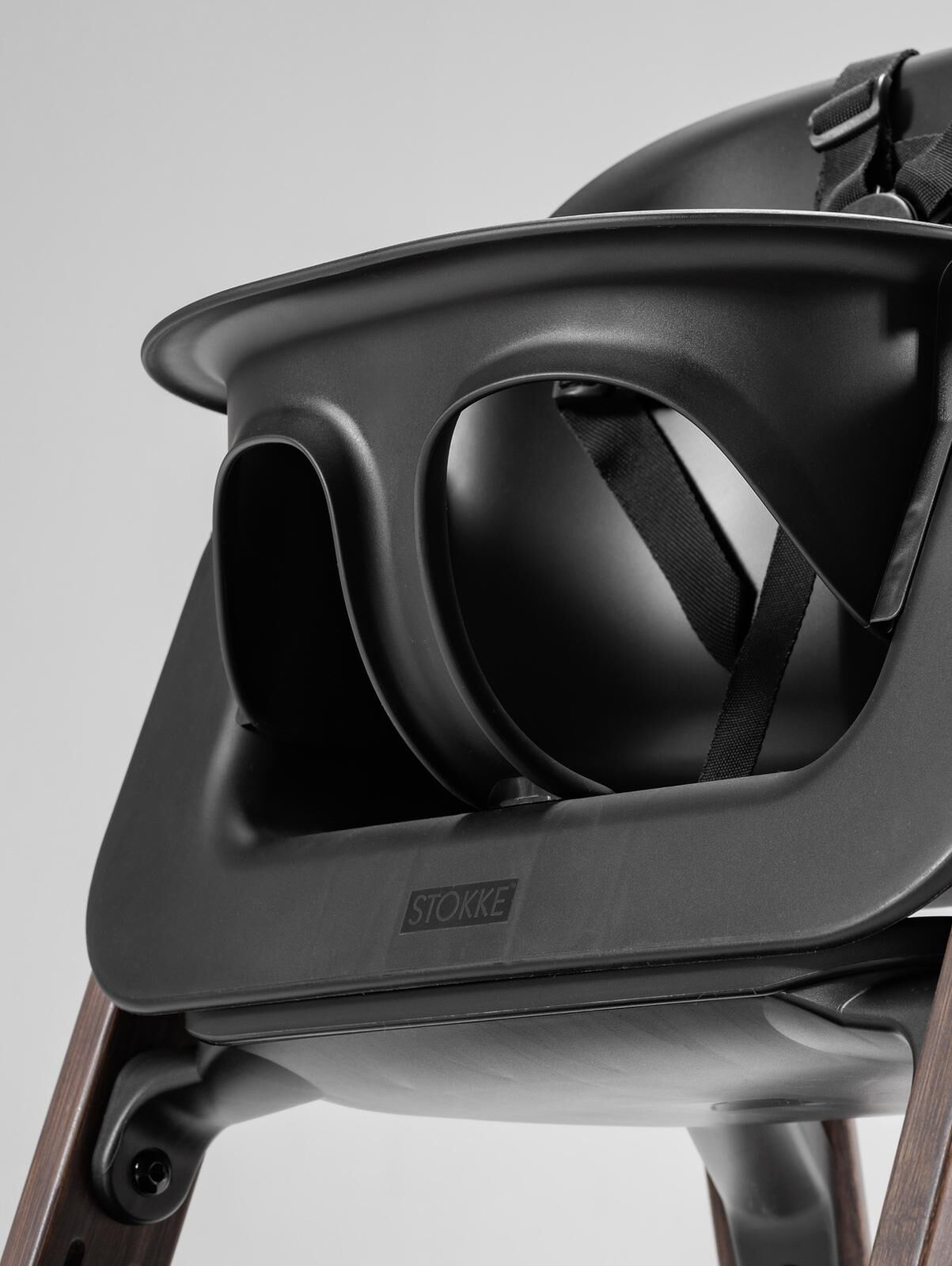 Dark grey Tripp Trapp high chair with Baby Set and black harness.