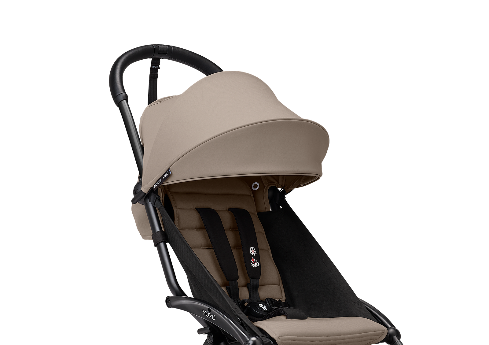En beige och svart STOKKE YOYO barnvagn mot en svart bakgrund.
