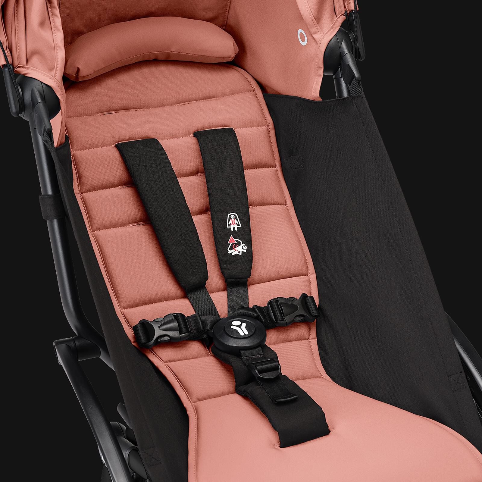 Close-up van een STOKKE YOYO kinderwagenzitje in gemberkleur, met zwart harnas.