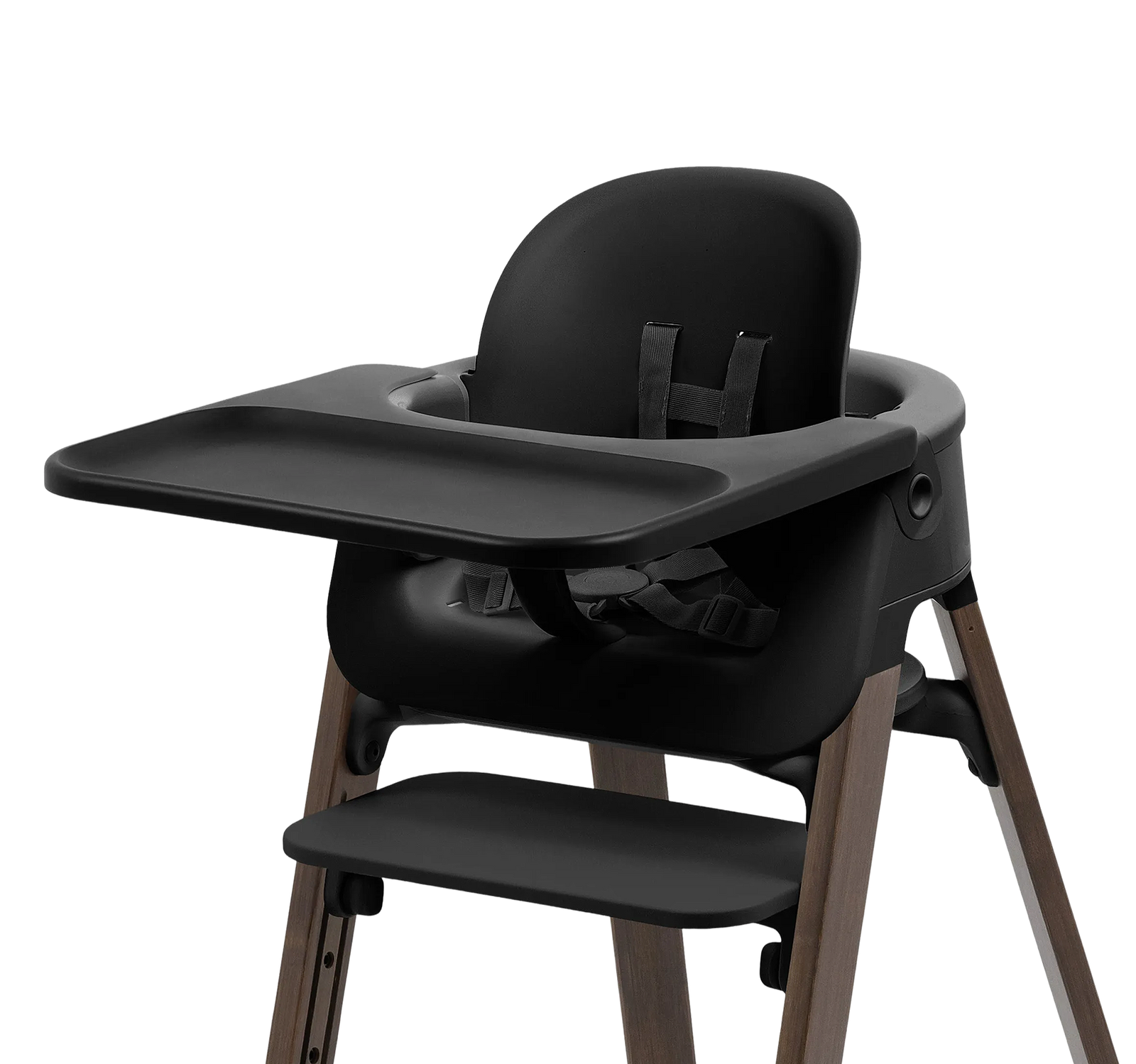 Black high chair with a tray, seat, footrest, and wooden legs on a black background.