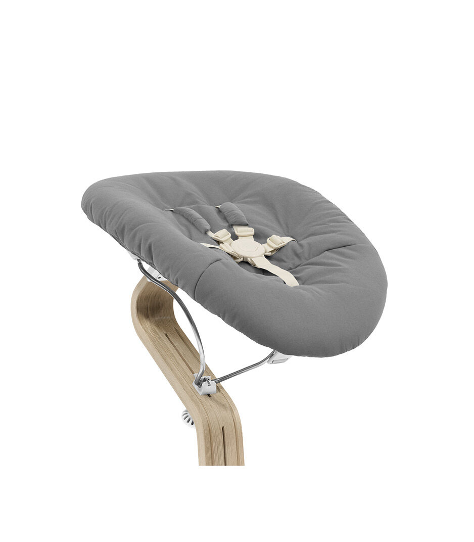 Stokke® Nomi® Chair Natural-White with Newborn Set Sand. Close-up.