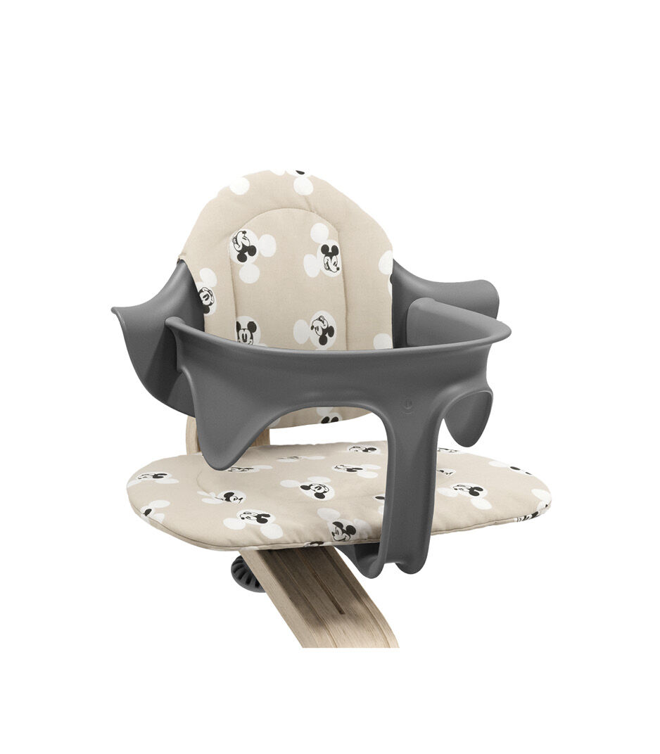 Stokke® Nomi® Chair Natural-Grey with Baby Set and Disney Cushion Mickey Signature. Close-up. Limited Edition.