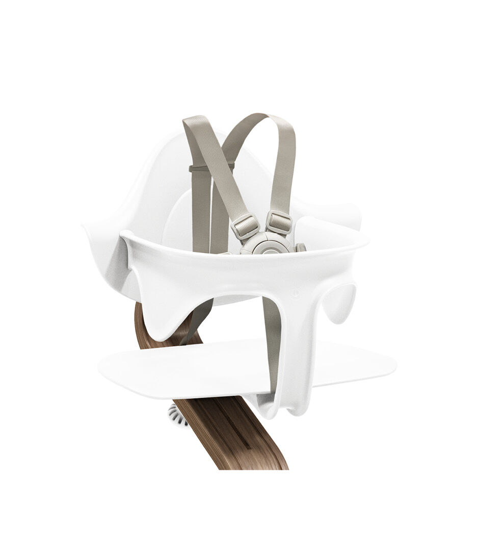 Stokke® Nomi® Chair. Premium Walnut wood and White plastic parts. With Baby Set White. US variant w/Harness. Close-up. galery image 3