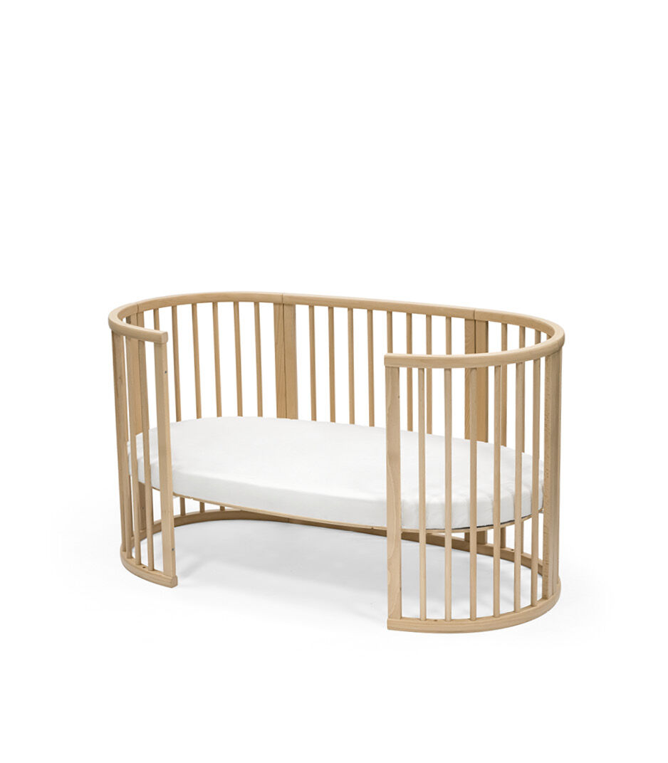 Stokke® Sleepi™ Bed, Natural. With Mattress and Fitted Sheet White. Open.