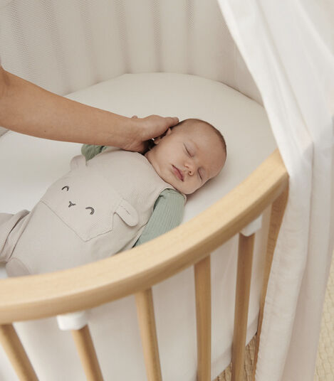 Stokke® Sleepi™ Mini V3, Natural. With Mattress, Mesh Liner and Canopy. Emotional close-up.  view 5