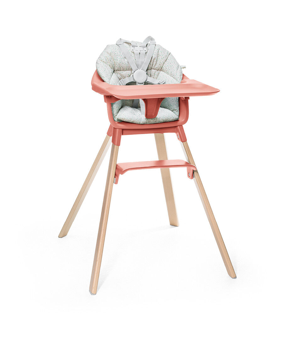 Stokke® Clikk™ High Chair. Natural Beech wood and Sunny Coral plastic parts including Tray. Cushion Grey Sprinkle and Harness.