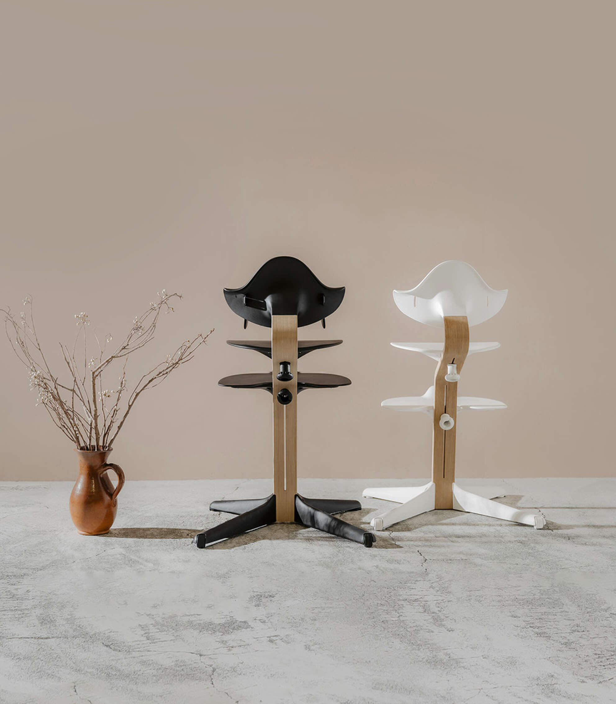 Two modern ergonomic chairs in black and white with wooden frames.