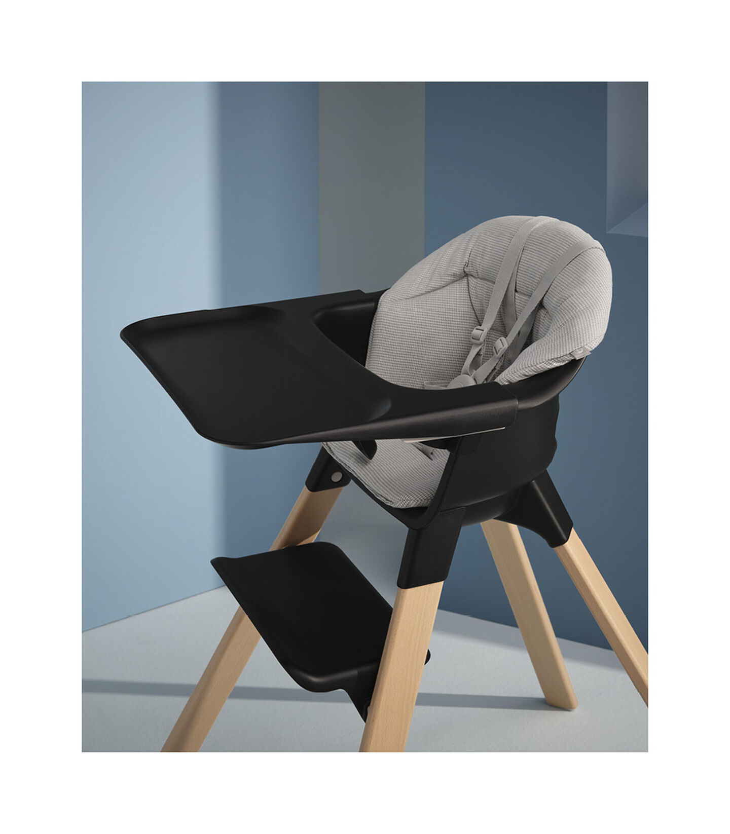 Stokke® Clikk™ High Chair Black with Natural Beech legs, and Nordic Grey cushion. Styled. view 2