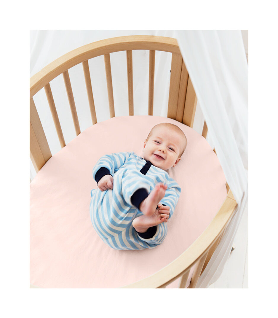 Stokke® Sleepi™ Mini Bed, Natural with Fitted Sheet Peachy Pink.