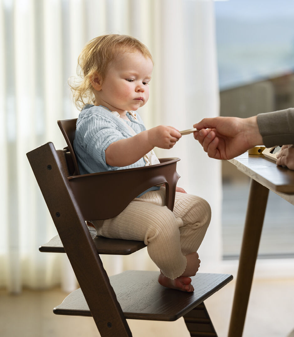 Tripp Trapp® Oak Warm Brown with Baby Set and Harness (US variant). Close-up.