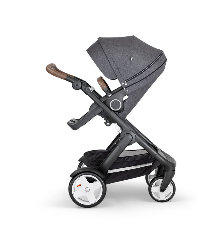 Stokke® Trailz™ with Black Chassis, Brown Leatherette and Classic Wheels. Stokke® Stroller Seat, Black Melange. view 1