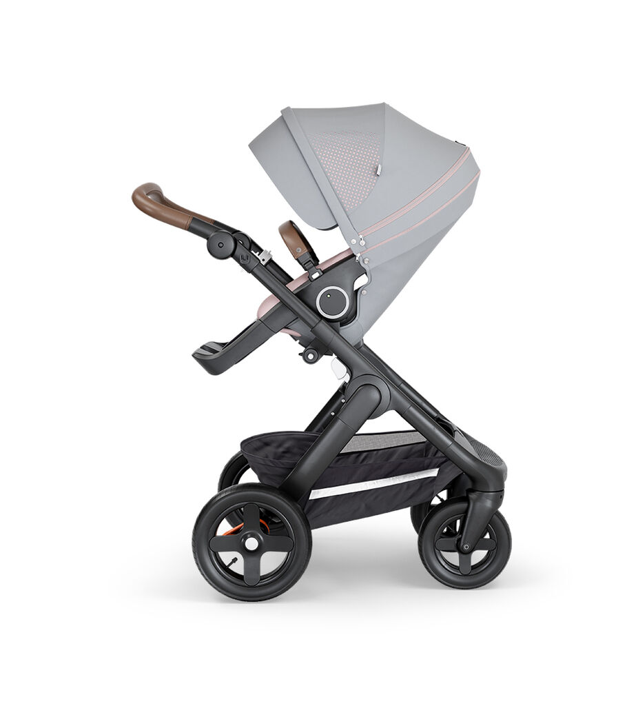 Stokke&reg; Trailz&trade; with Black Chassis, Brown Leatherette and Terrain Wheels. Stokke&reg; Stroller Seat, Athleisure Pink.