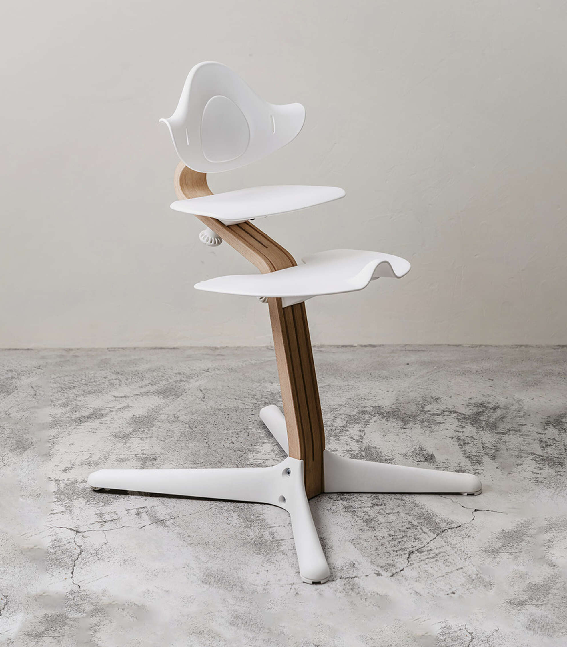 Side view of white-and-wood high chair with adjustable fittings.