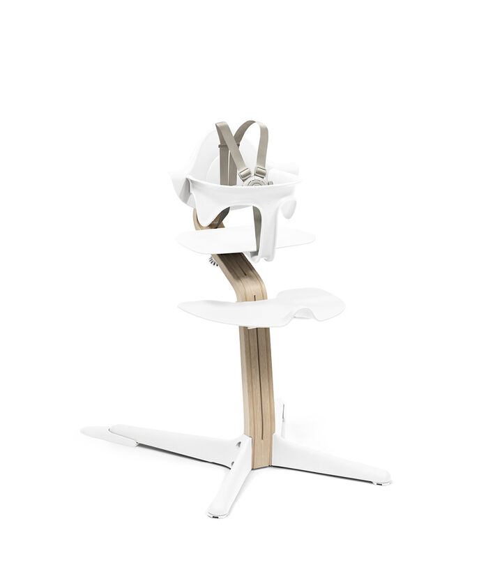 Stokke® Nomi® Chair Natural-White with Baby Set. US variant w/Harness. view 1