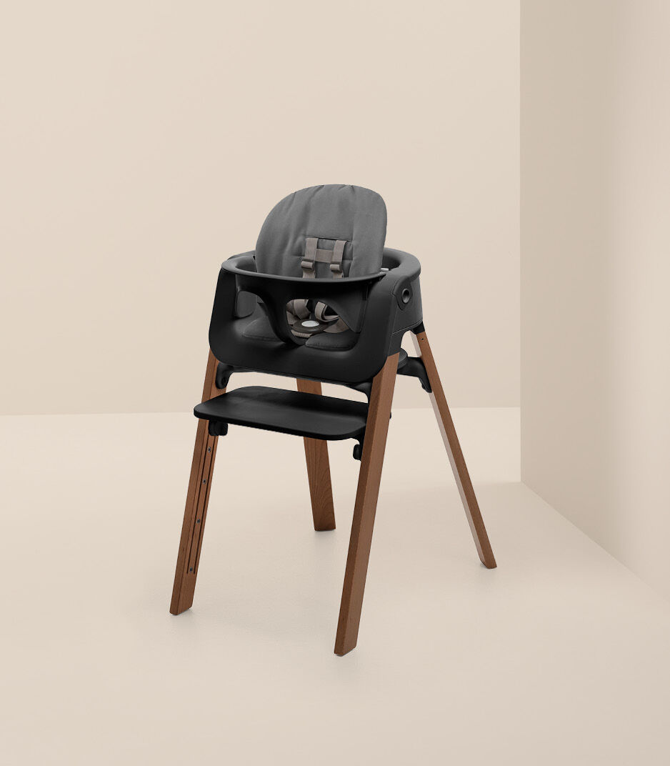 Stokke® Steps™ Chair Golden Brown with Baby Set Black and Cushion Herringbone Grey.