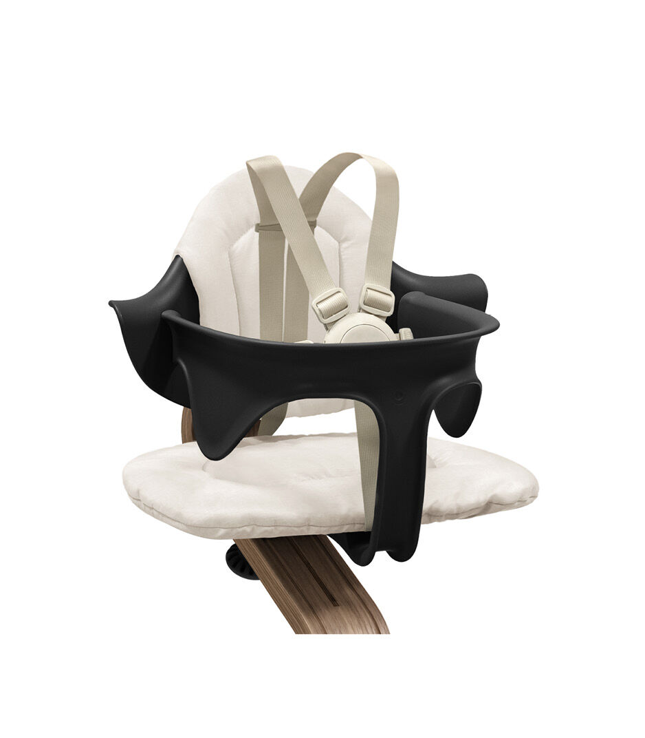 Stokke® Nomi® Chair. Walnut/Black. With Baby Set and Cushion Sand. US variant with Harness and Leg Extensions. Close-up. galery image 9