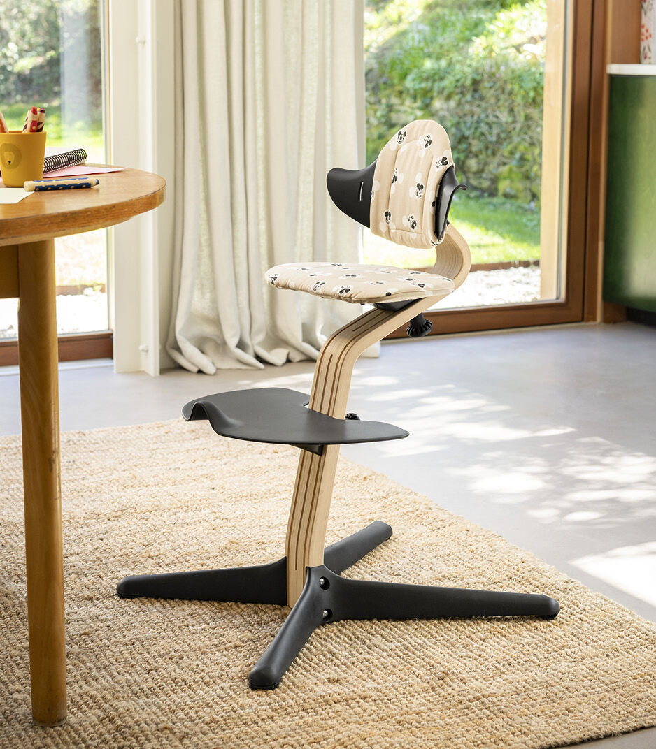 Stokke® Nomi® Chair Natural/Black with Disney Mickey Signature cushion.