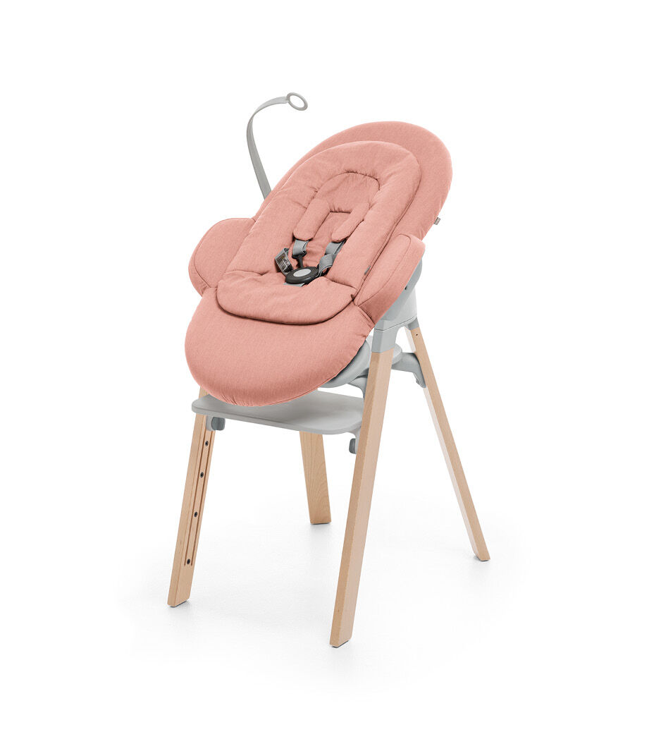 Stokke® Steps™ Natural and Light Grey plastic with Stokke® Steps Bouncer in Soft Coral.