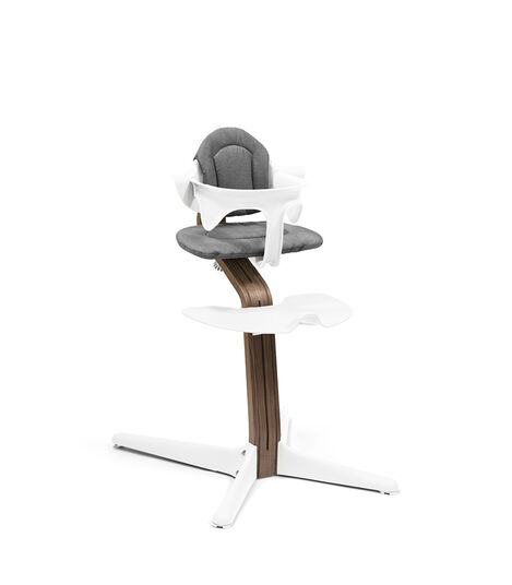 Stokke® Nomi® Chair. Premium Walnut wood and White plastic parts. With Baby Set Grey and Cushion White. view 2