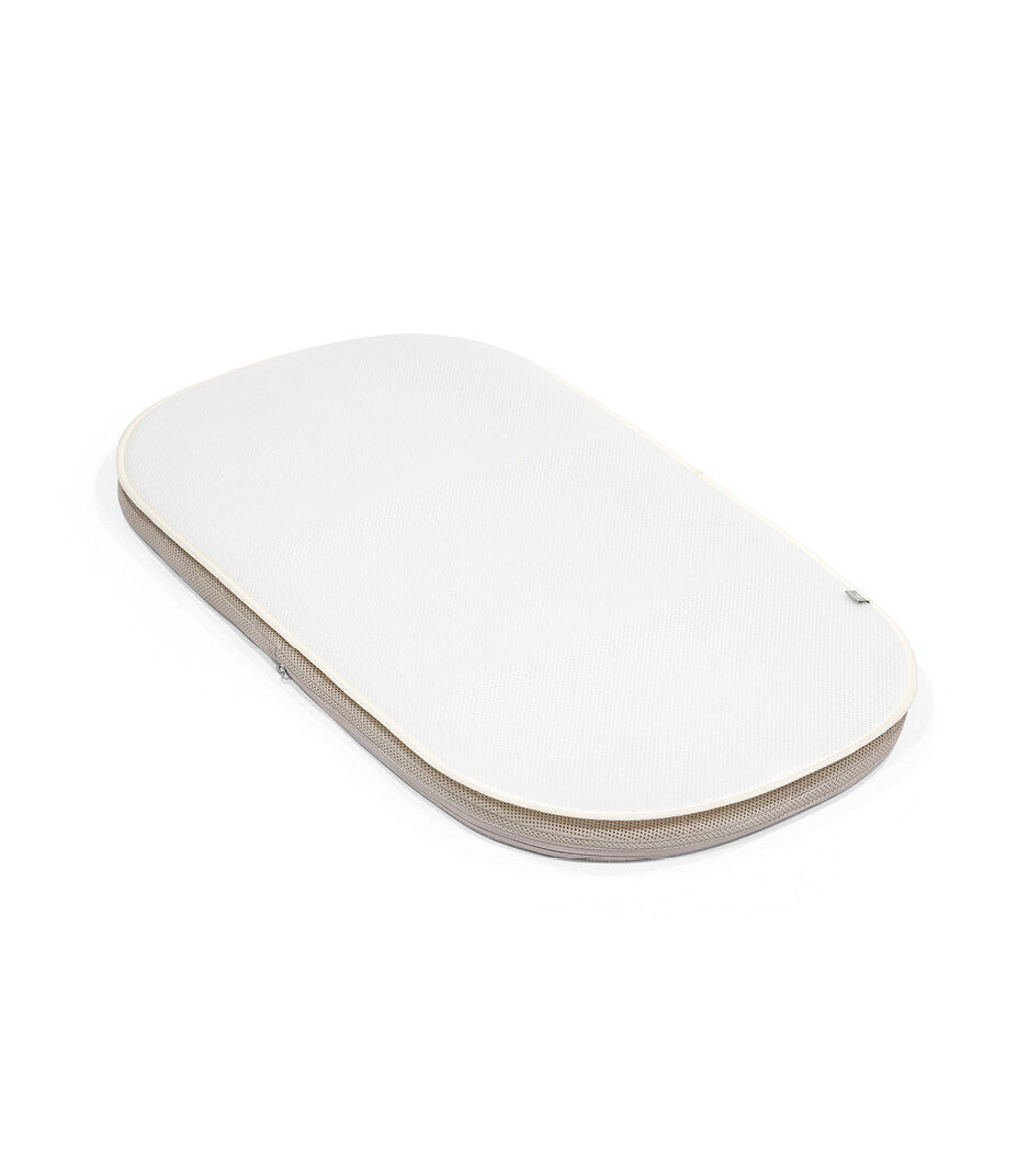 Stokke Snoozi™ Protection Sheet Vanilla Cream. On top of matress.