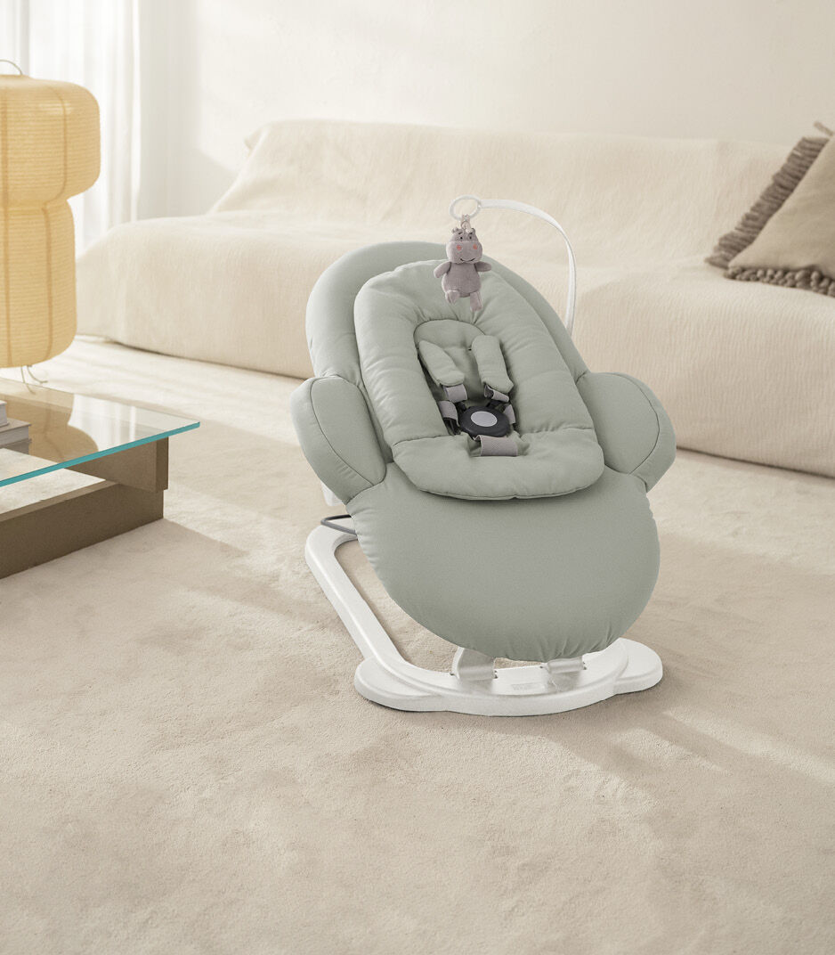 Stokke® Steps™ Bouncer. White chassis, Soft Sage Textile Set and Toy Hanger.