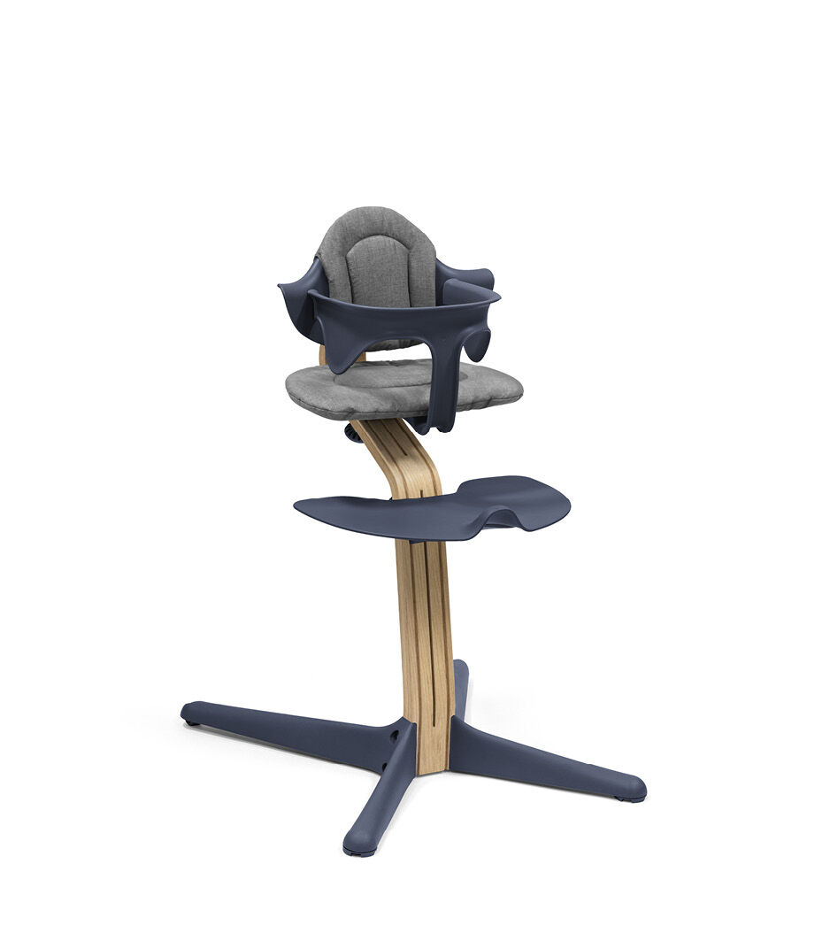 Stokke® Nomi® Chair. Premium Oak wood and Navy plastic parts. With Baby Set Grey and Cushion Grey.