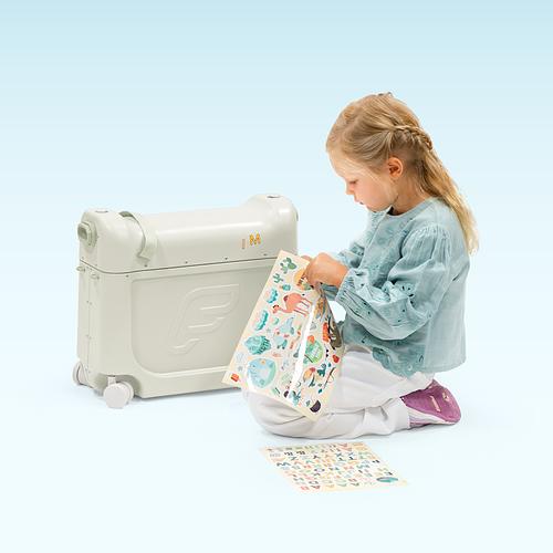 Young girl customizes her JetKids BedBox with stickers.​