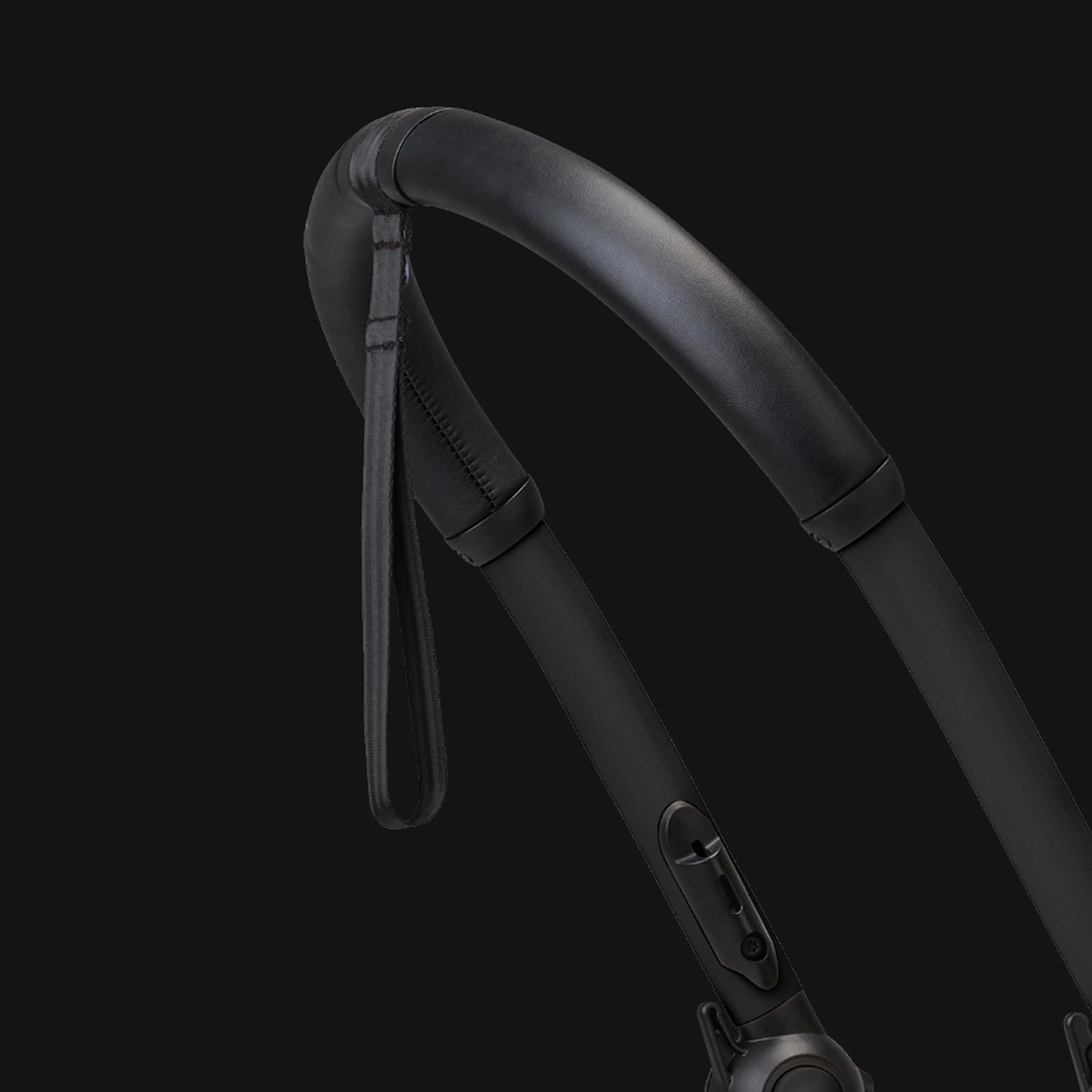 Close-up of a black padded handle and wrist strap of a STOKKE YOYO stroller.