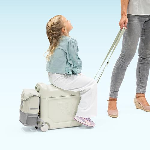 Young child using a JetKids ride-on luggage.​