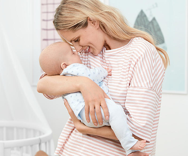 Frau hält ein Baby im Arm