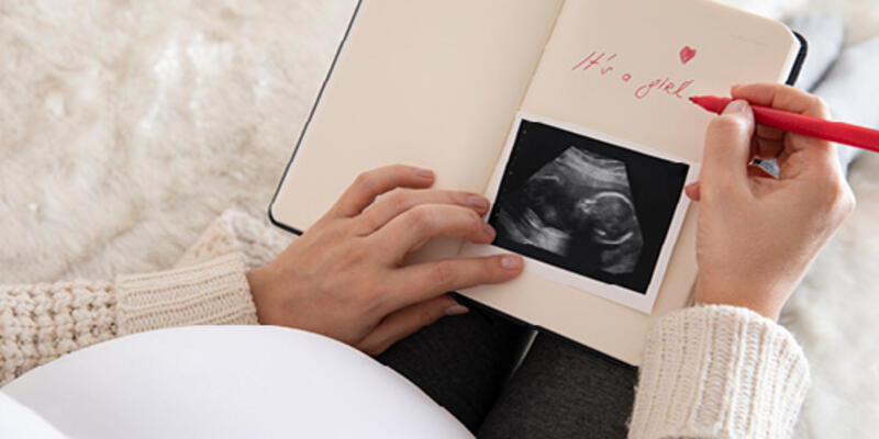 A pregnant woman writing 
