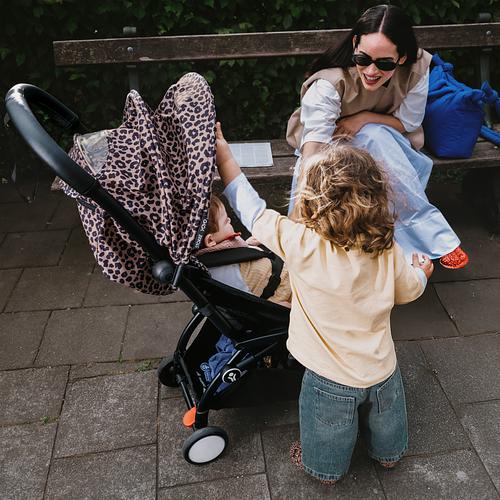 Child and mother sitting on bench next to animal print YOYO.