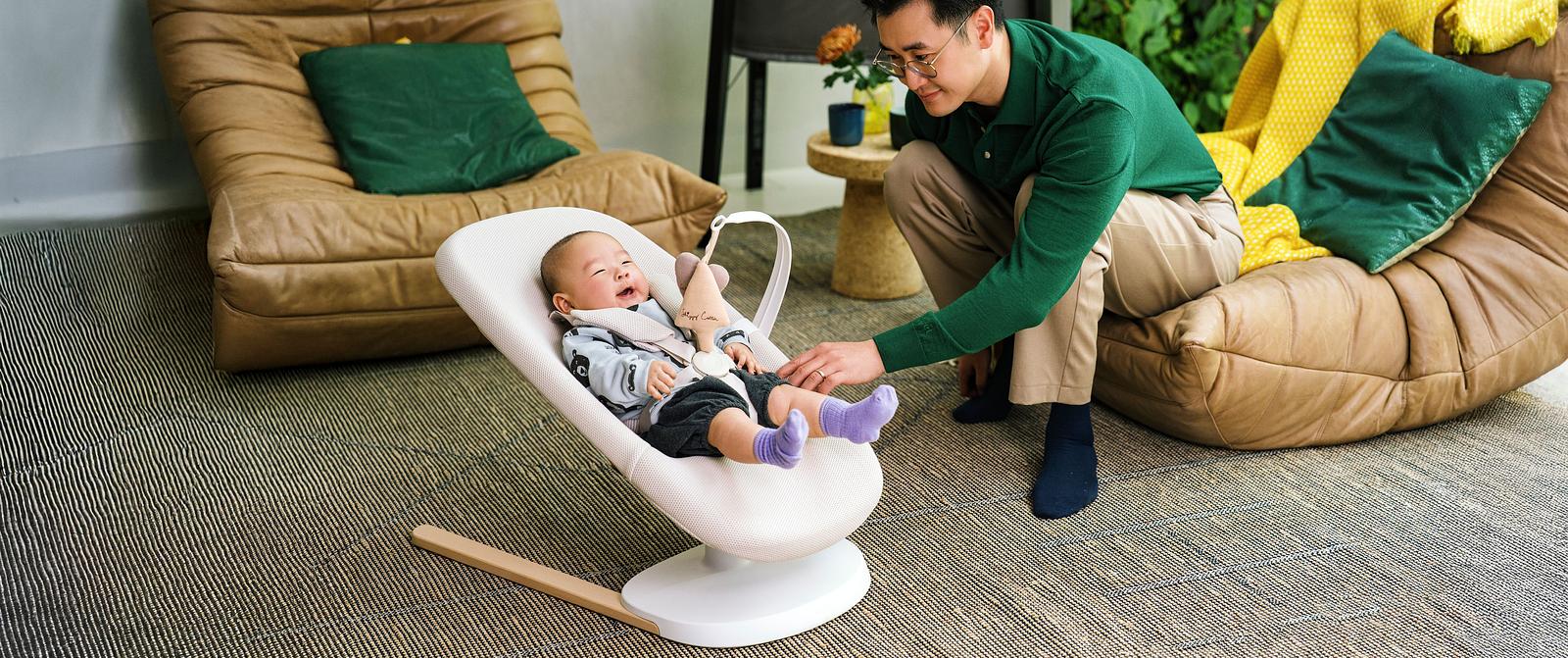 Baby is enjoying playing while laying in the baby bouncer