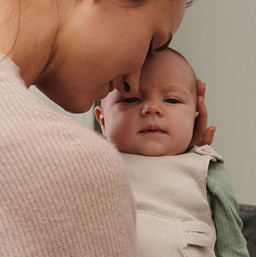 Mom holding newborn baby close.