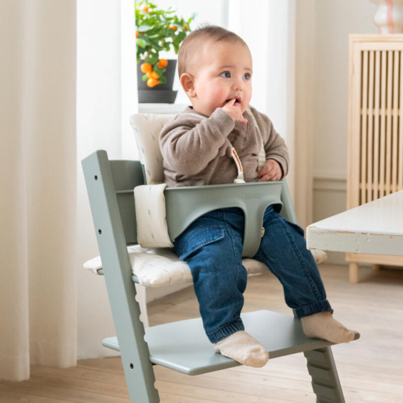 Baby in tripp trapp high chair color glacier green and wheat cream cushion.