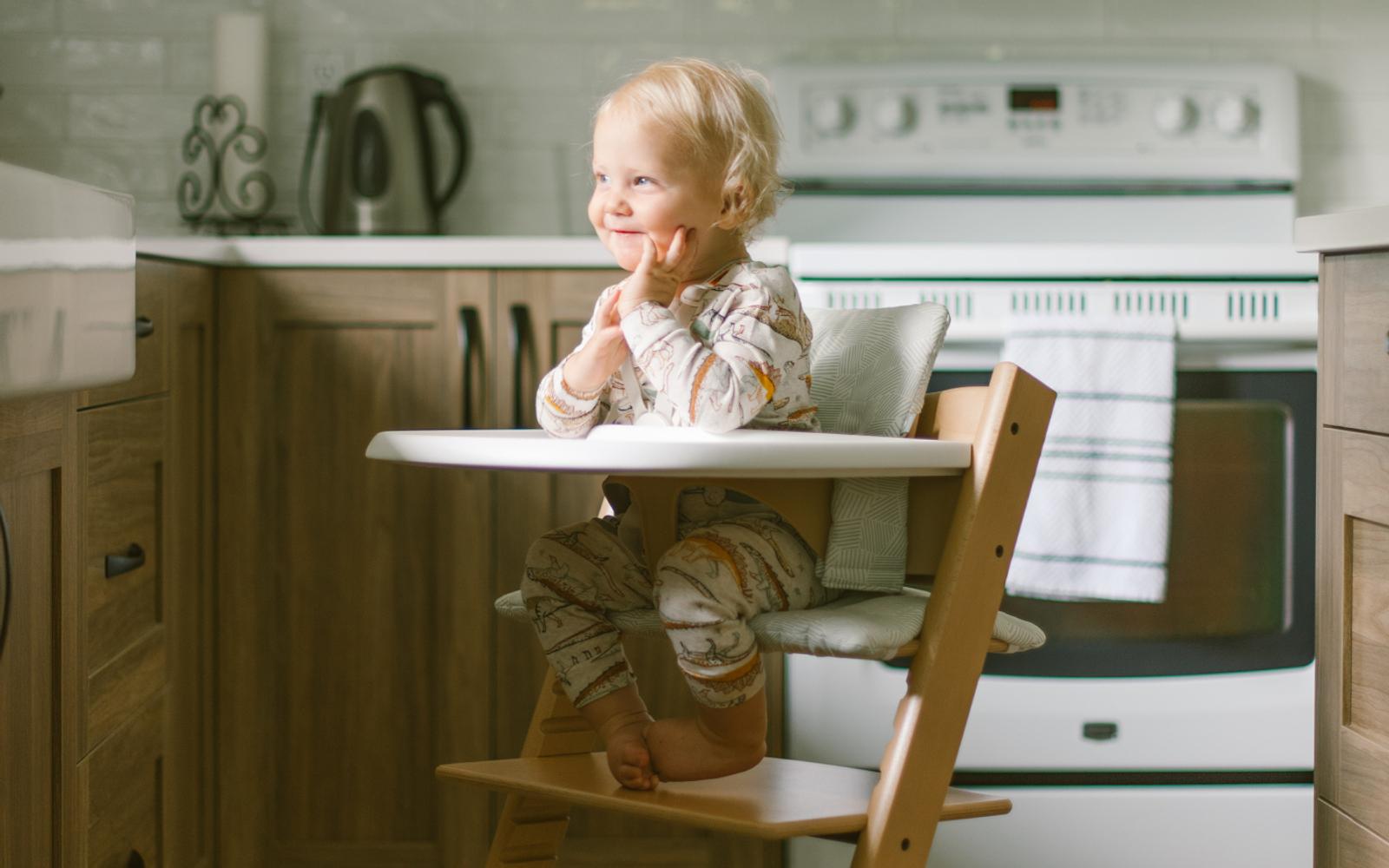 Baby sitting in Tripp Trapp high chair. Summer savings 20% off select Tripp Trapp.