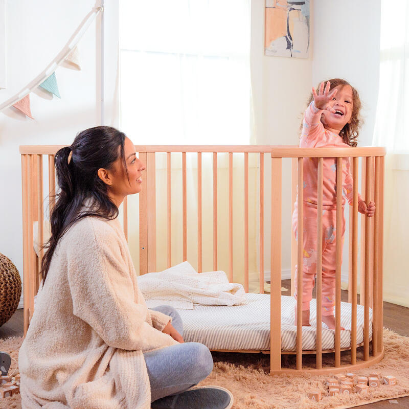 Mother looking at her child standing in their Sleepi™ Bed.