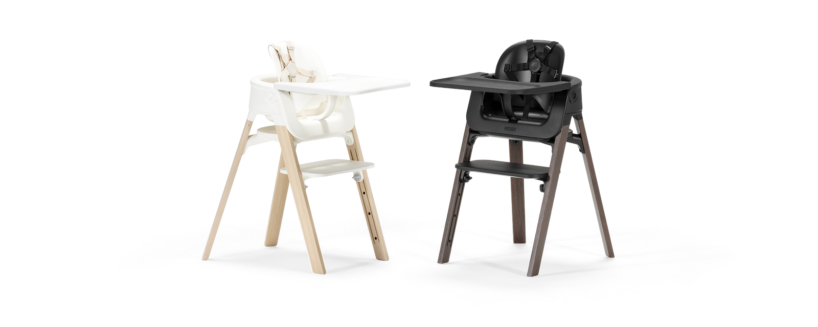Deux chaises hautes, une blanche avec des pieds en bois clair, une noire avec des pieds en bois foncé.
