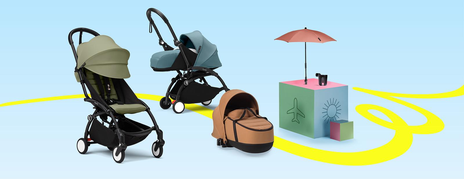 Three YOYO strollers in different colors next to each other, and a parasol and a cup holder positioned on boxes on the right.