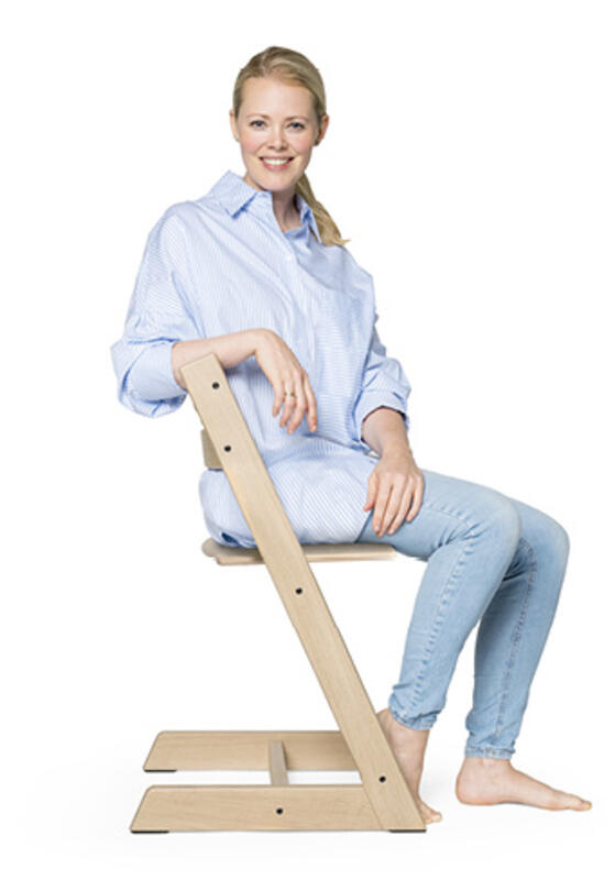 woman sitting on tripp trapp chair