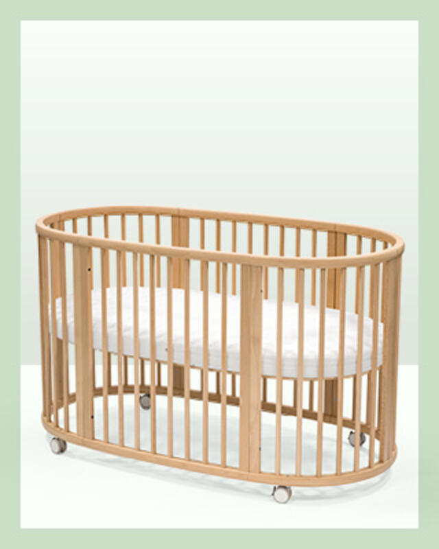 A Sleepi Bed crib in natural wood color with white mattress. A baby registry essential.