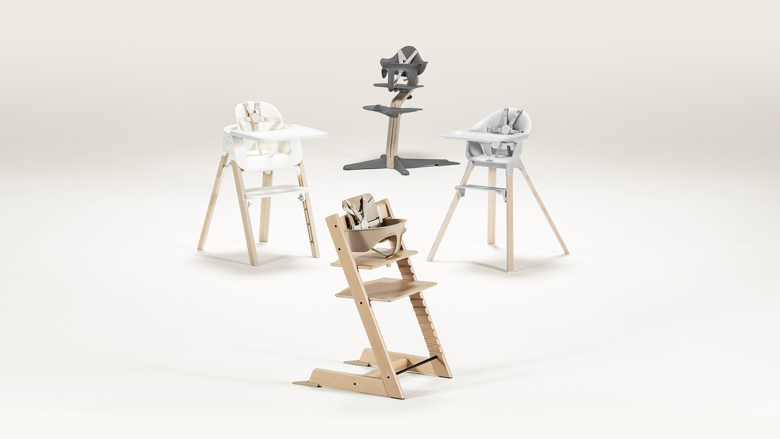 Four high chairs: a natural Tripp Trapp, two wooden high chairs, and one grey high chair.